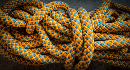 Macro closeup of coiled dynamic climbing rope. Abstract background. Themes of connection, trust, athleticism, strength, teamwork or unity. Journey or growth. © mailcaroline