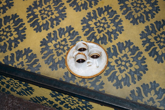 Coffee cups on a tray on a patterned table