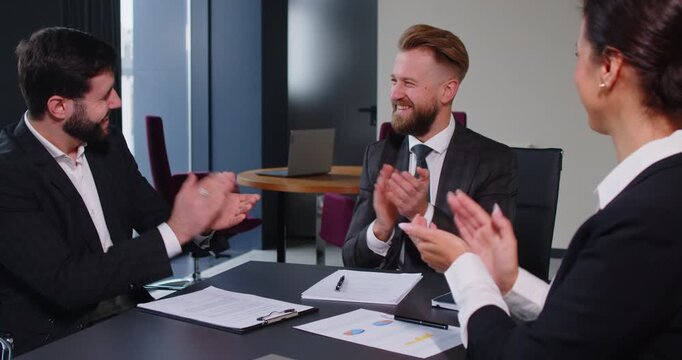 Team of a business people applaud and celebrate success during a professional office conference. Teamwork, collaboration, and achievement define this motivational and productive meeting.