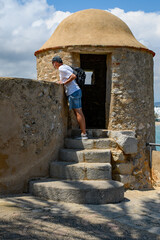 Man looking over the wall next to a turret to see the view from Peniscola city castle or Castillo del Papa Luna, located at the highest point. Costa del Azahar, province of Castellon, Valencian 