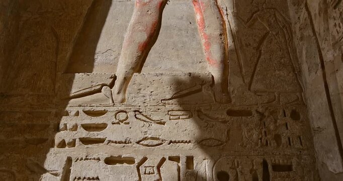 Closeup of ancient Egyptian hieroglyphic inscriptions with cartouches and bird symbols carved in sandstone wall at Medinet Habu temple in Luxor Egypt, detailed royal text. Downscaled from 6k.
