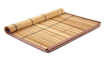 A close-up shot of a partially rolled-up woven mat made from natural bamboo, resting on a flat, rectangular surface