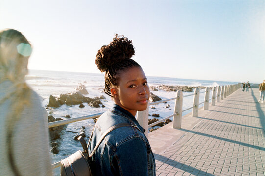 Woman walking on a boardwalk looking back at the camera.