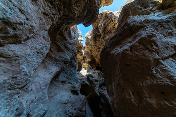 Obraz premium Sesriem Canyon in Namibia, an impressive natural gorge in the Namib Desert shaped by thousands of years of erosion from the Tsauchab River. Dramatic rock formations, narrow passages, and warm sandston