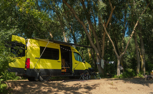 Cozy Camper Van Parked In Trees Shadows Near Sea Beach
