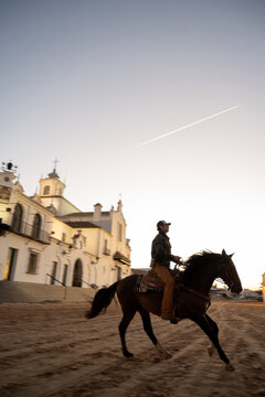 Cowboy Galloping Mustang Past Church At Sunset