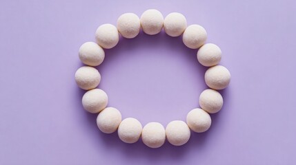 Obraz premium Overhead shot of mochi donuts forming circular wreath shape, pastel lavender background