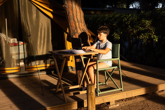 A child at a campsite doing his homework