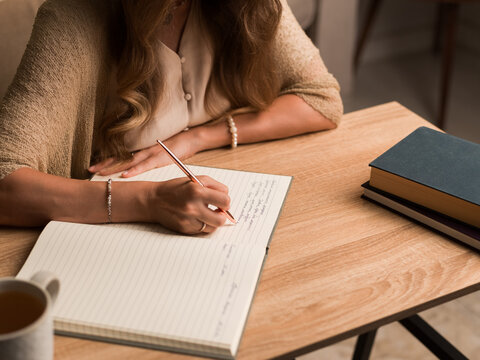 Writing Notes at a Wooden Table in a Cozy Setting