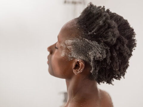 Woman Washing Her Curly Hair in a Bright Bathroom Setting