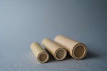 Fototapeta premium Three Natural Bamboo Tubes on Gray Background