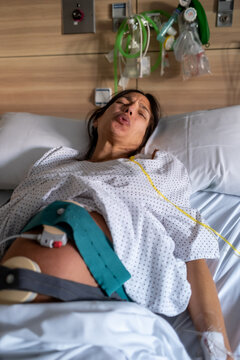 Pregnant Woman In Pain During Labor On Hospital Bed