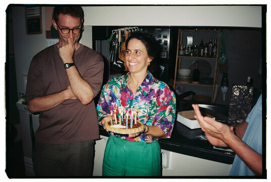 Celebrating a Birthday With Cake and Friends in a Cozy Kitchen