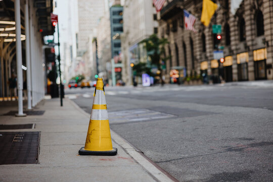 Yellow Traffic Cone on City Sidewalk