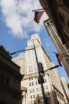 Tall City Buildings with American Flags Against Blue Sky