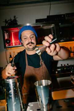 Bartender Measuring Liquor Behind Bar