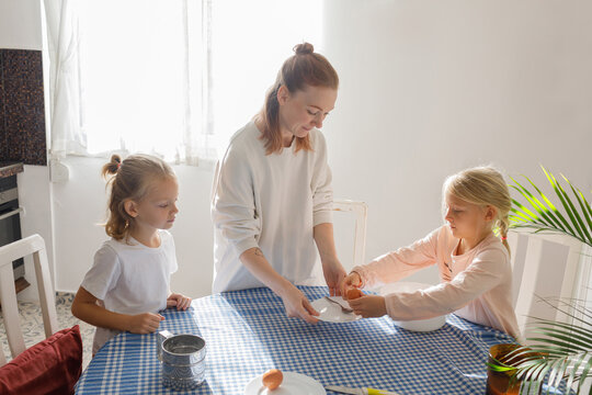 Mother and children are setting the table for breakfast