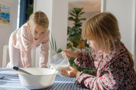 Young sisters are preparing breakfast