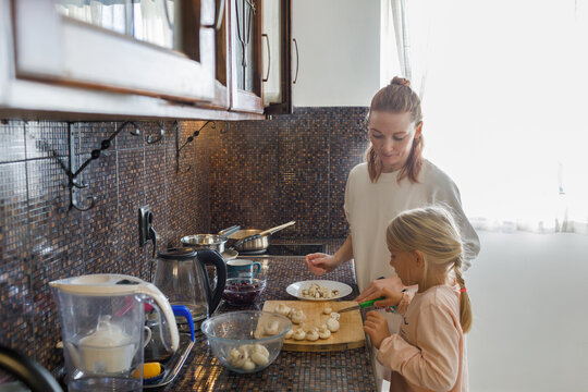 Woman and little daughter cooking in the kitchen