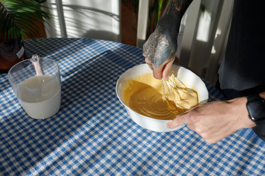 Man whisking dough in a bowl