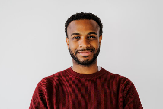 Man smiling while looking at camera against white background