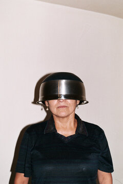 Playful Portrait of Woman Wearing Metal Bowl as Helmet
