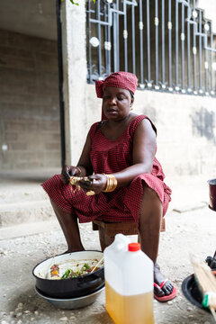 African woman preparing street food kebabs in Senegal