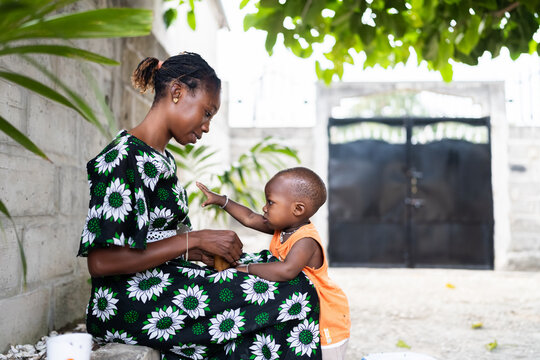 African mother bonding with baby in Senegal outdoors