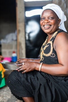 Joyful Senegalese woman smiling holding tray outdoors