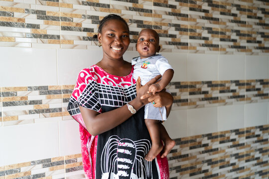 African mother holding baby boy smiling happily in Senegal