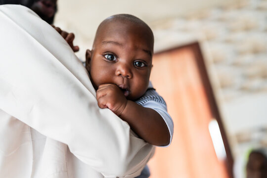 Baby boy looking at camera while being held