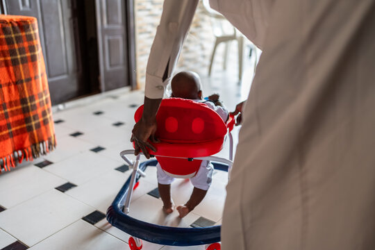 Parent helping baby learning to walk in Senegal