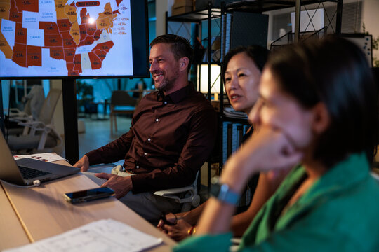 Business team reviews data on a screen in a meeting.
