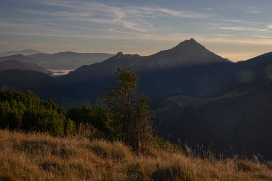 View of sunlight kissing the peaks of distant mountains as shadows dance across the valleys in Mala Fatra, Zilina Region, Slovakia.