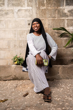 Smiling Young African Woman in Hijab Sitting