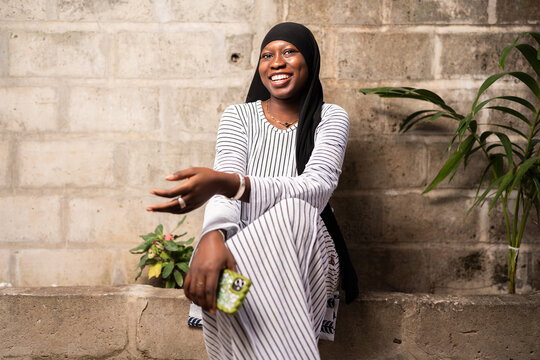 Young Senegalese woman smiling and communicating outdoors