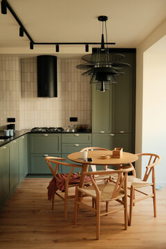 Vertical photo of cozy modern kitchen with warm tones, no one present 