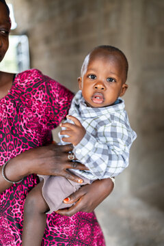 African mother holding her baby boy in Senegal