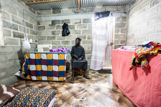 African man operating small business weaving textiles in Senegal