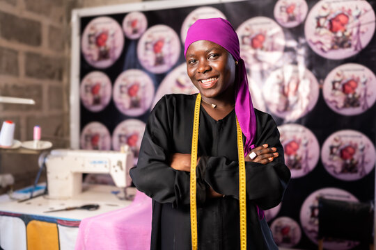 African female fashion designer smiling in her workshop