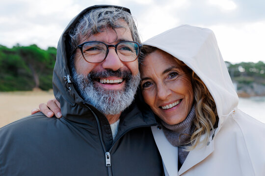 Couple smiling happy in hooded jackets outdoors