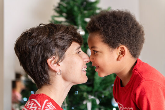 Smiling Mother and Son Share a Moment Near Christmas Tree