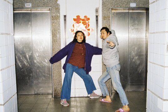 Couple posing to the camera in front of elevators