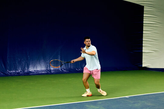 Man prepares to strike the tennis ball