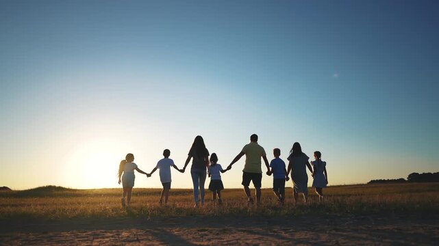 big family. huge community family holding hands walking in the park at sunset. happy family kid dream concept. big family community walking with children in the park sunlight. friendly people walking