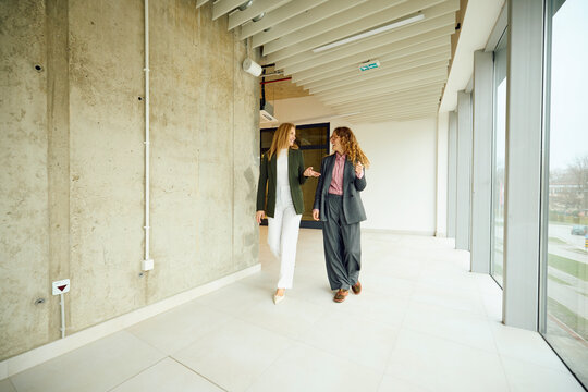 Elegant women walk through corporate building