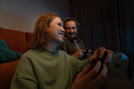 Father and son enjoying video games together at home