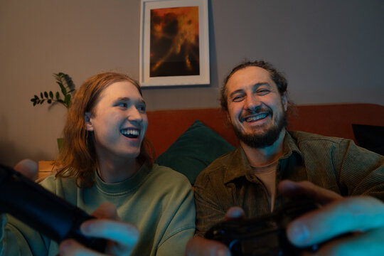 Father and son laughing while playing video games at home