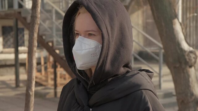 Woman Outdoors Wearing Mask With Red Valve, Hooded Coat, Outdors, Maintaining Distance, Health. Protection Mask for Health. Eco Volunteer, FFP3 KN99 Filter Respirator, Safety, Environmental problem