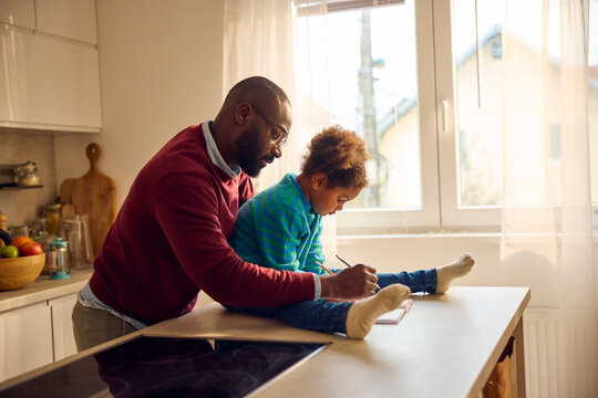Father helps his child with schoolwork